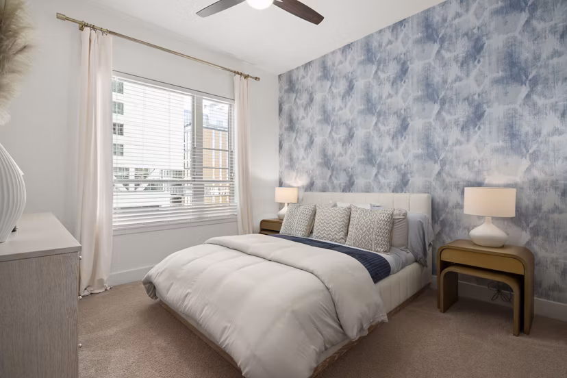 Bedroom featuring modern decor and ample natural light at Tens on West Apartments