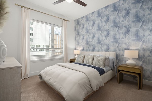 Bedroom featuring modern decor and ample natural light at Tens on West Apartments