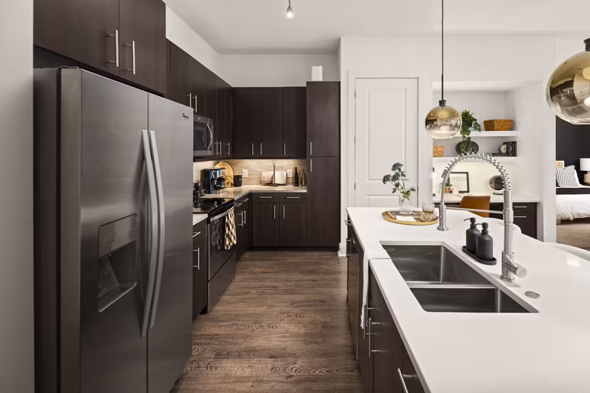 Modern kitchen with stainless steel appliances at Tens on West Apartments, a luxury living space by Greystar