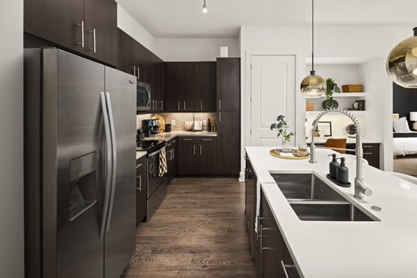 Modern kitchen with stainless steel appliances at Tens on West Apartments, a luxury living space by Greystar