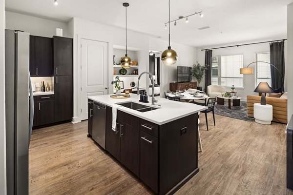 Kitchen featuring modern appliances and granite countertops at Tens on West Apartments
