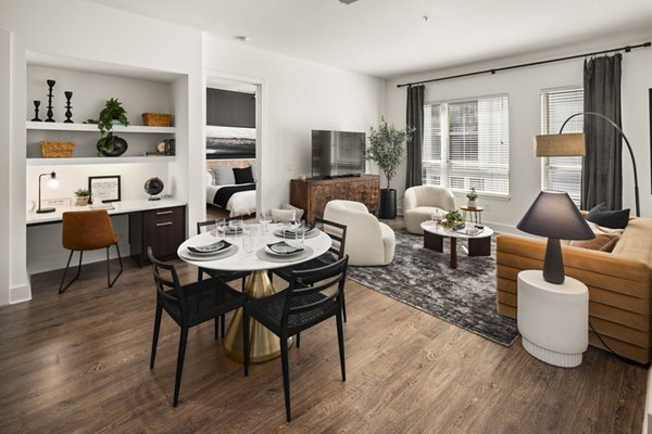 Spacious living room featuring modern decor and large windows at Tens on West Apartments, offering luxury living in an urban setting