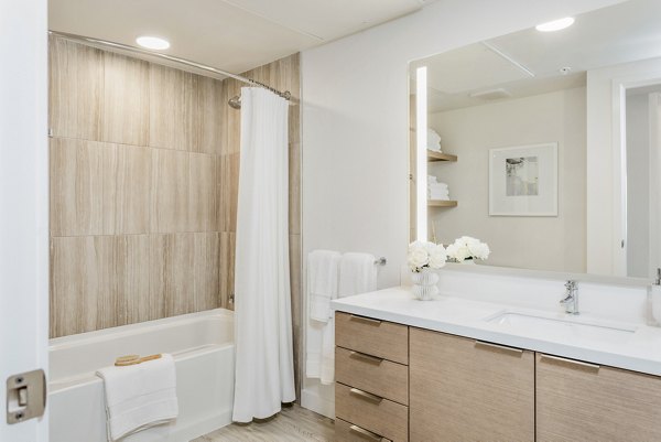 Modern bathroom with large vanity and sleek fixtures at Valentina by Alta Apartments in San Diego
