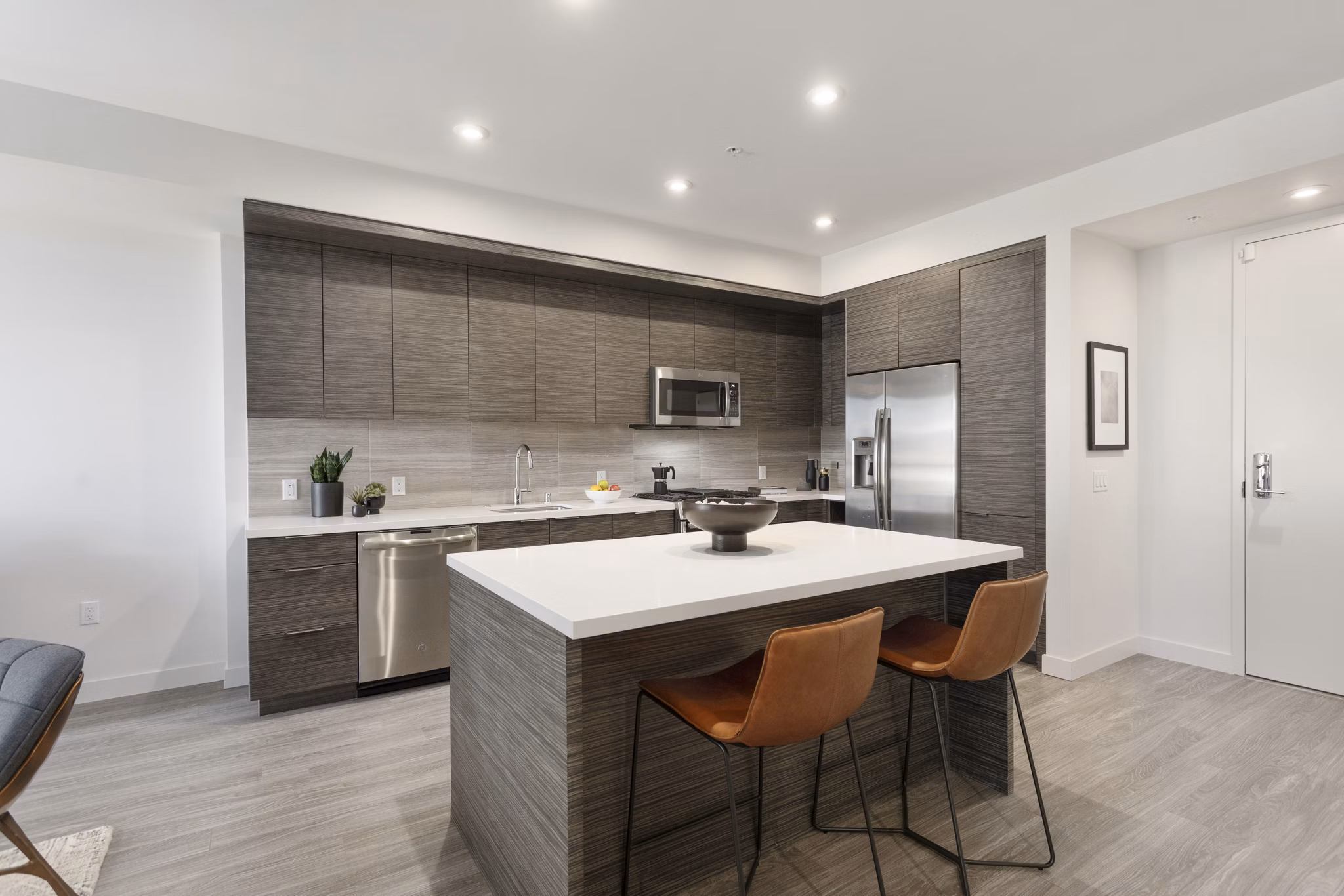 Contemporary kitchen with stainless steel appliances and marble countertops in Valentina by Alta Apartments, luxury living in San Diego