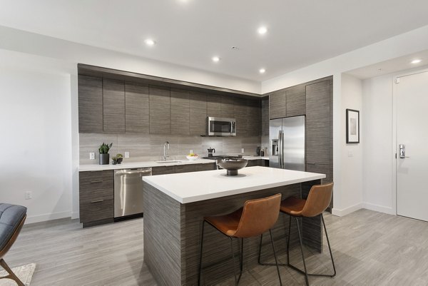 Contemporary kitchen with stainless steel appliances and marble countertops in Valentina by Alta Apartments, luxury living in San Diego