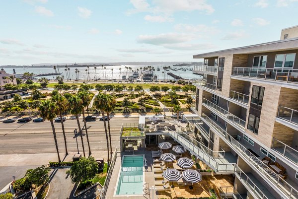 Luxurious poolside relaxation area at Valentina by Alta Apartments, featuring loungers and skyline views