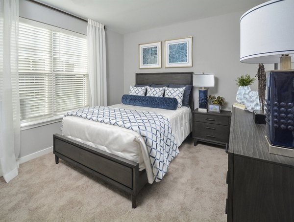 Bedroom featuring modern design and cozy comforts in The Wexley at 100 Apartments