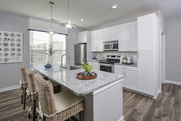 Modern kitchen featuring stainless steel appliances at The Wexley at 100 Apartments
