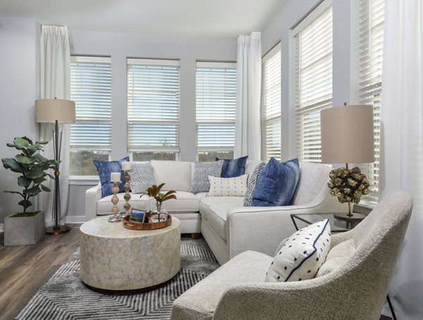 Spacious living room with modern furnishings at The Wexley at 100 Apartments, featuring luxury design and comfortable seating