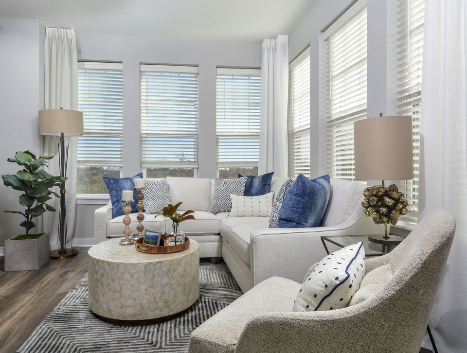 Spacious living room with modern furnishings at The Wexley at 100 Apartments, featuring luxury design and comfortable seating