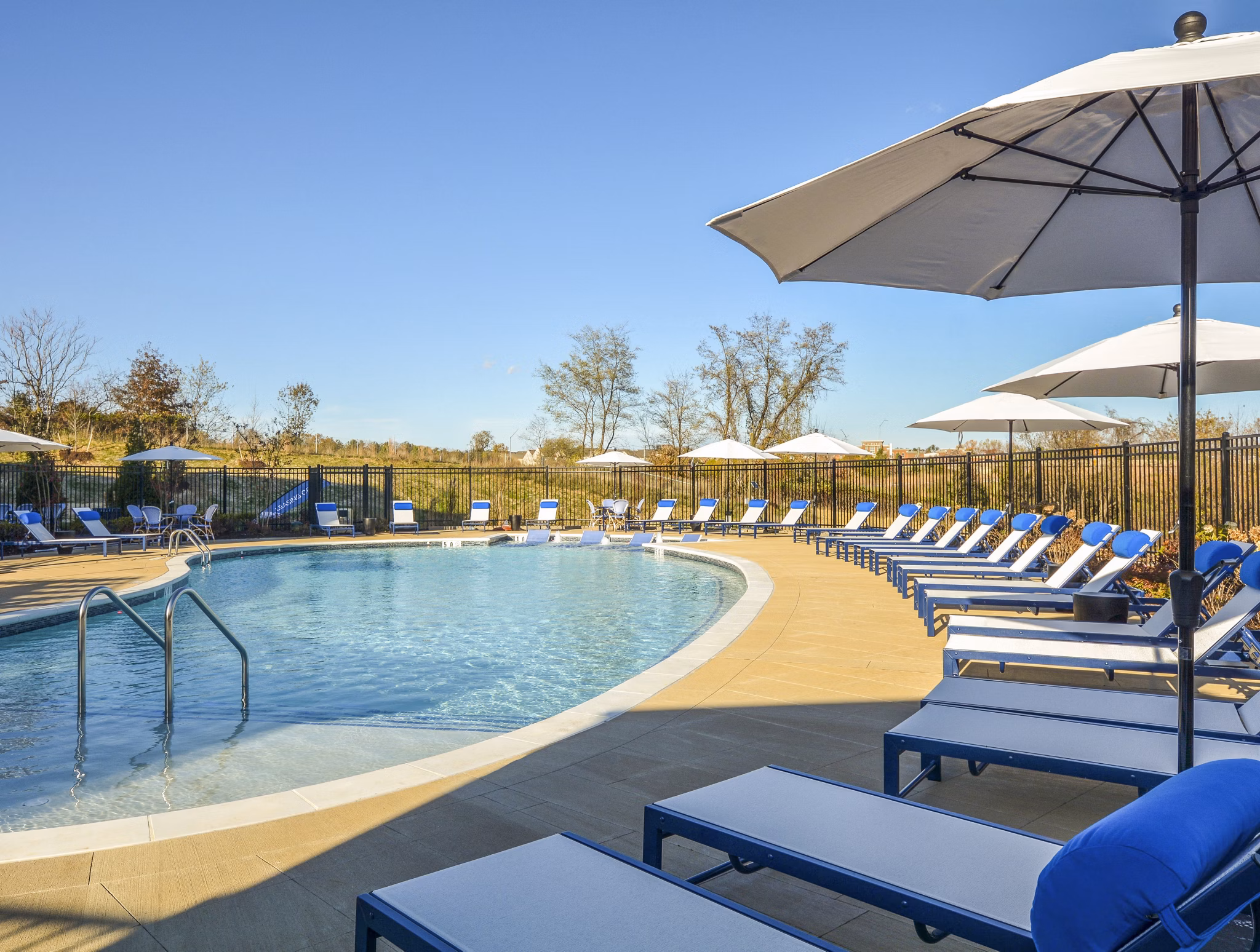 Luxurious pool area with lounging chairs at The Wexley at 100 Apartments, perfect for relaxation and social gatherings