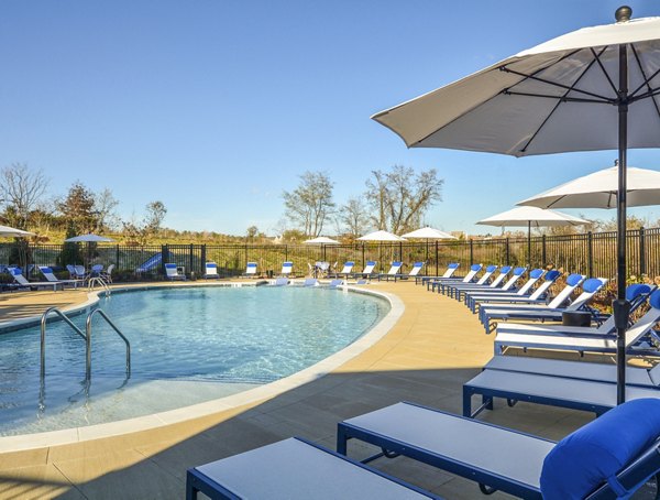 Luxurious pool area with lounging chairs at The Wexley at 100 Apartments, perfect for relaxation and social gatherings