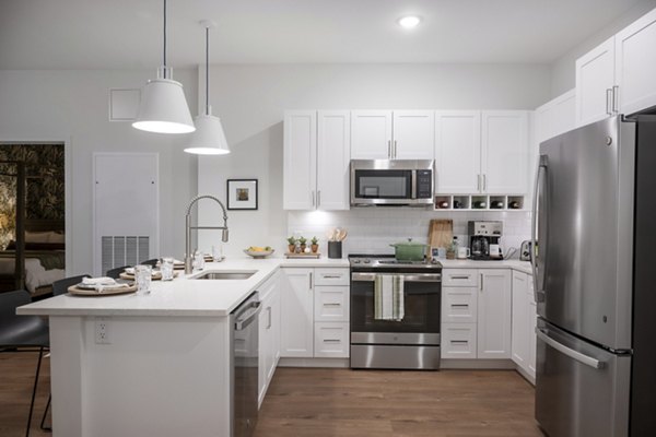Modern kitchen with stainless steel appliances in The Lodge Apartments