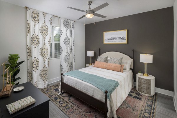 Bedroom with modern decor and natural light at The Clara by Broadstone Apartments