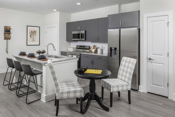 Dining area with modern lighting and sleek tableware at The Clara by Broadstone Apartments