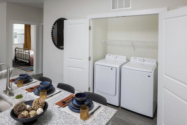 Laundry room with modern appliances at The Clara by Broadstone Apartments