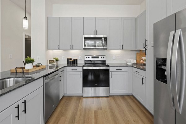 Modern kitchen with stainless steel appliances at Flats at General Time Apartments