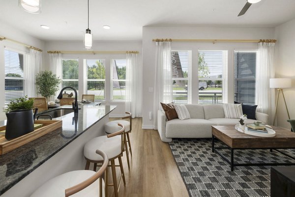 Modern living room featuring stylish decor and large windows at Flats at General Time Apartments