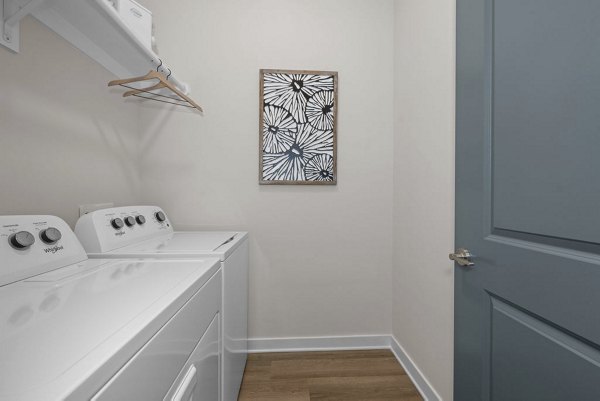 Modern laundry facility at Flats at General Time Apartments, featuring state-of-the-art equipment and ample folding space for resident convenience