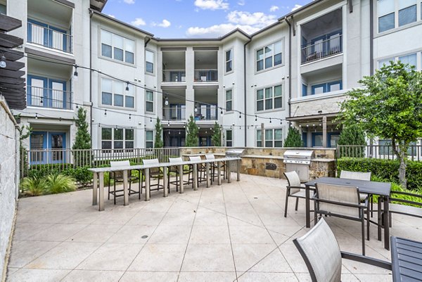 Outdoor grill area with modern seating at Domain at Midtown Park Apartments