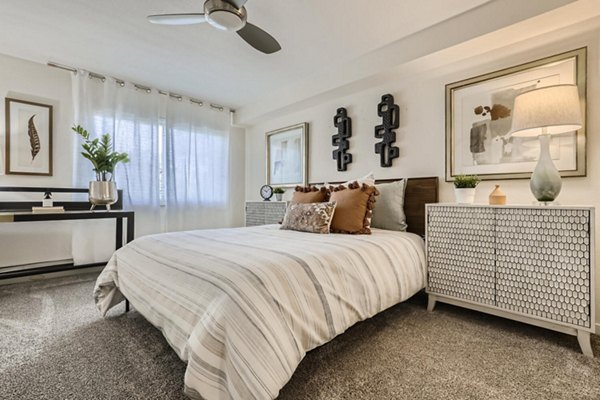 Avantus Apartments: Cozy bedroom with modern furnishings and large windows