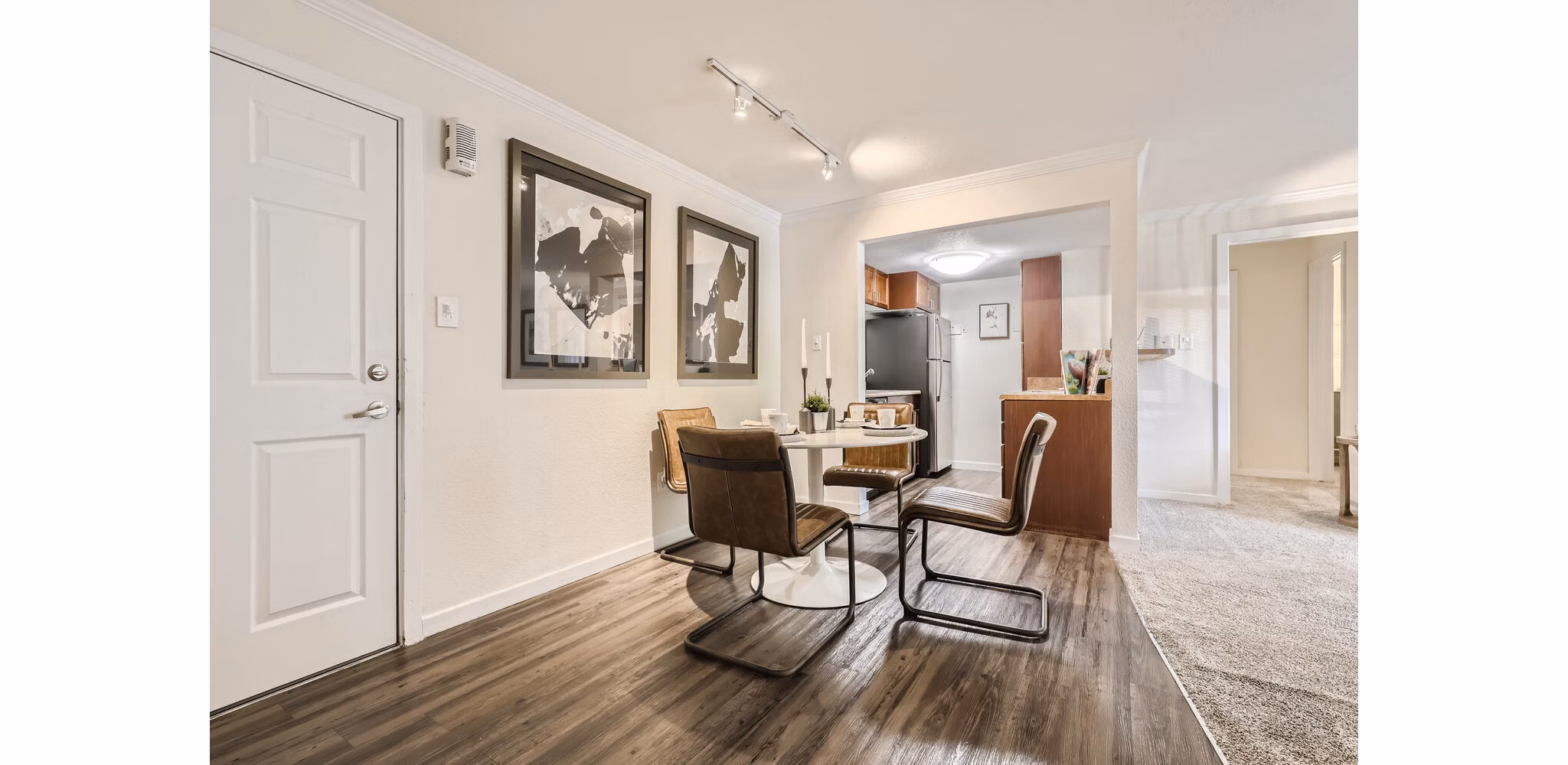 Elegant dining area with modern lighting at Avantus Apartments, featuring sleek furniture and open layout for luxury living in the city