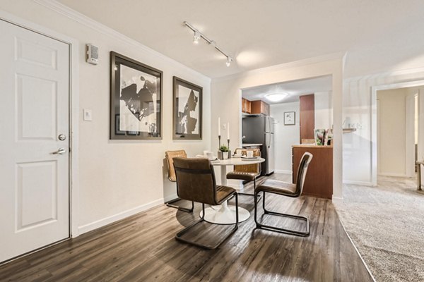 Elegant dining area with modern lighting at Avantus Apartments, featuring sleek furniture and open layout for luxury living in the city