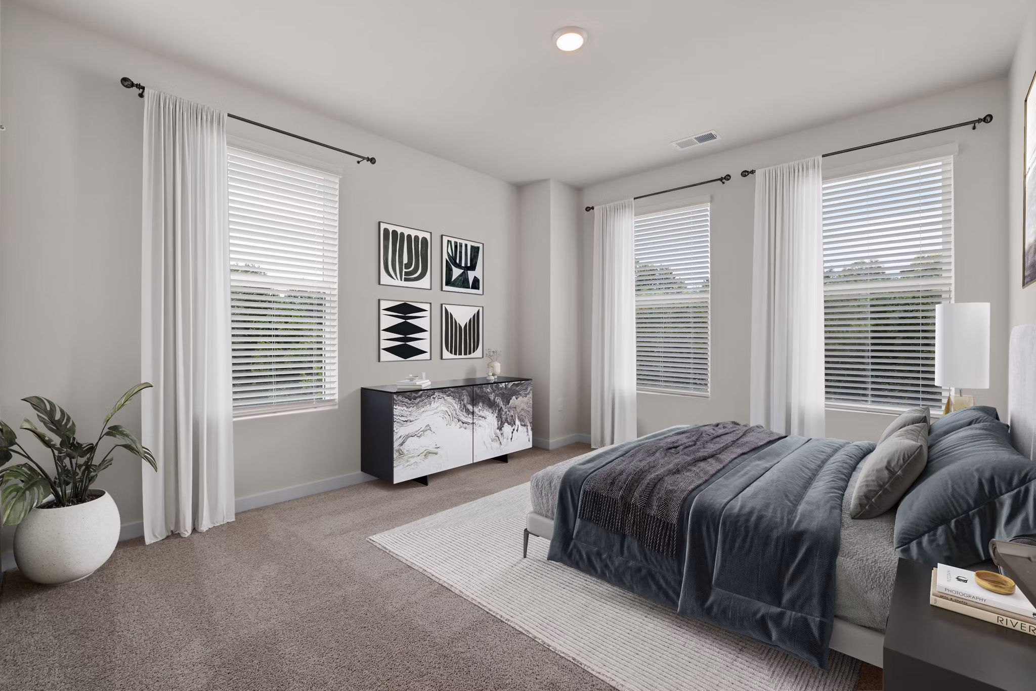 Elegant bedroom featuring modern furnishings and large windows at Gladwen Wendell Falls Apartments