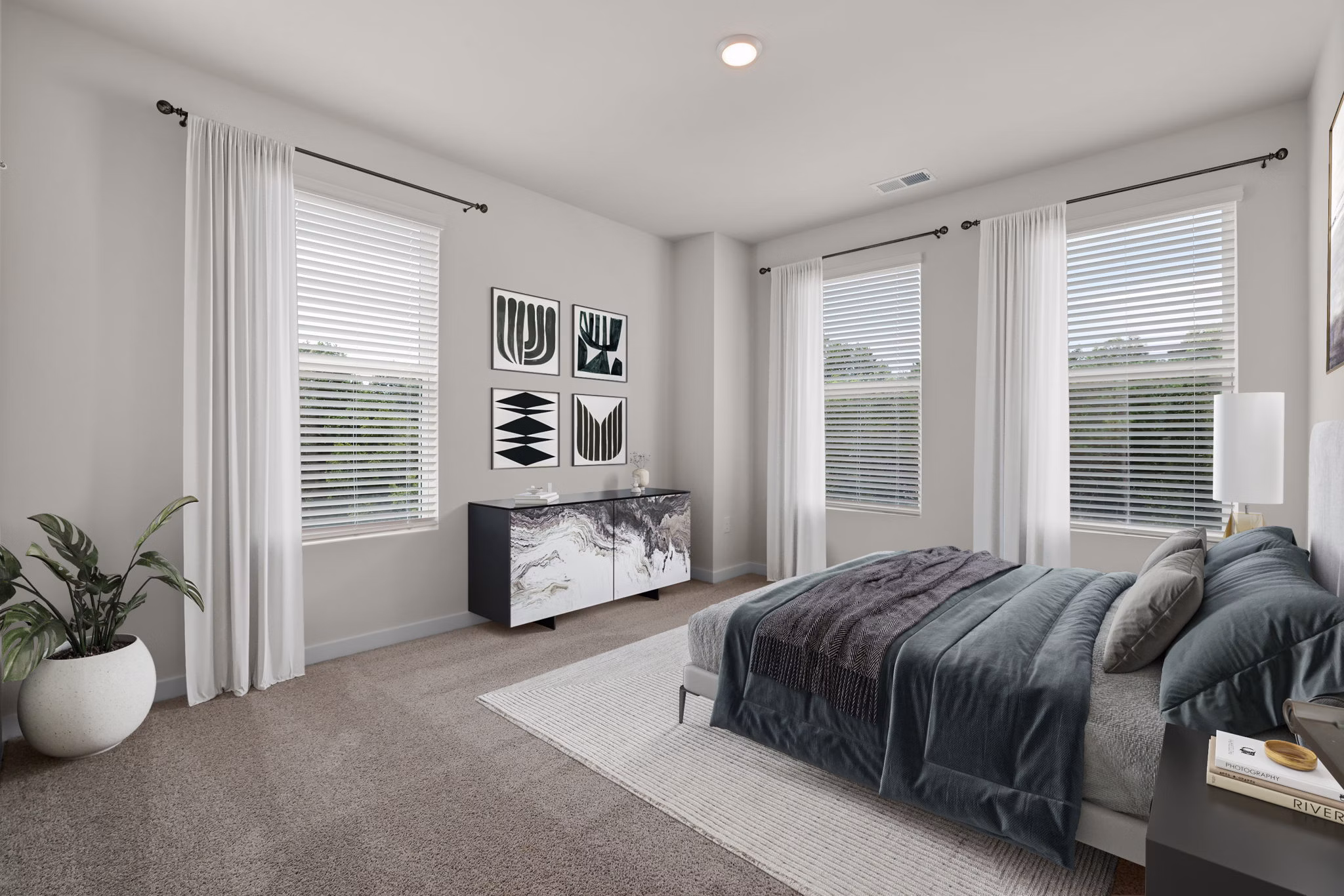 Elegant bedroom featuring modern furnishings and large windows at Gladwen Wendell Falls Apartments