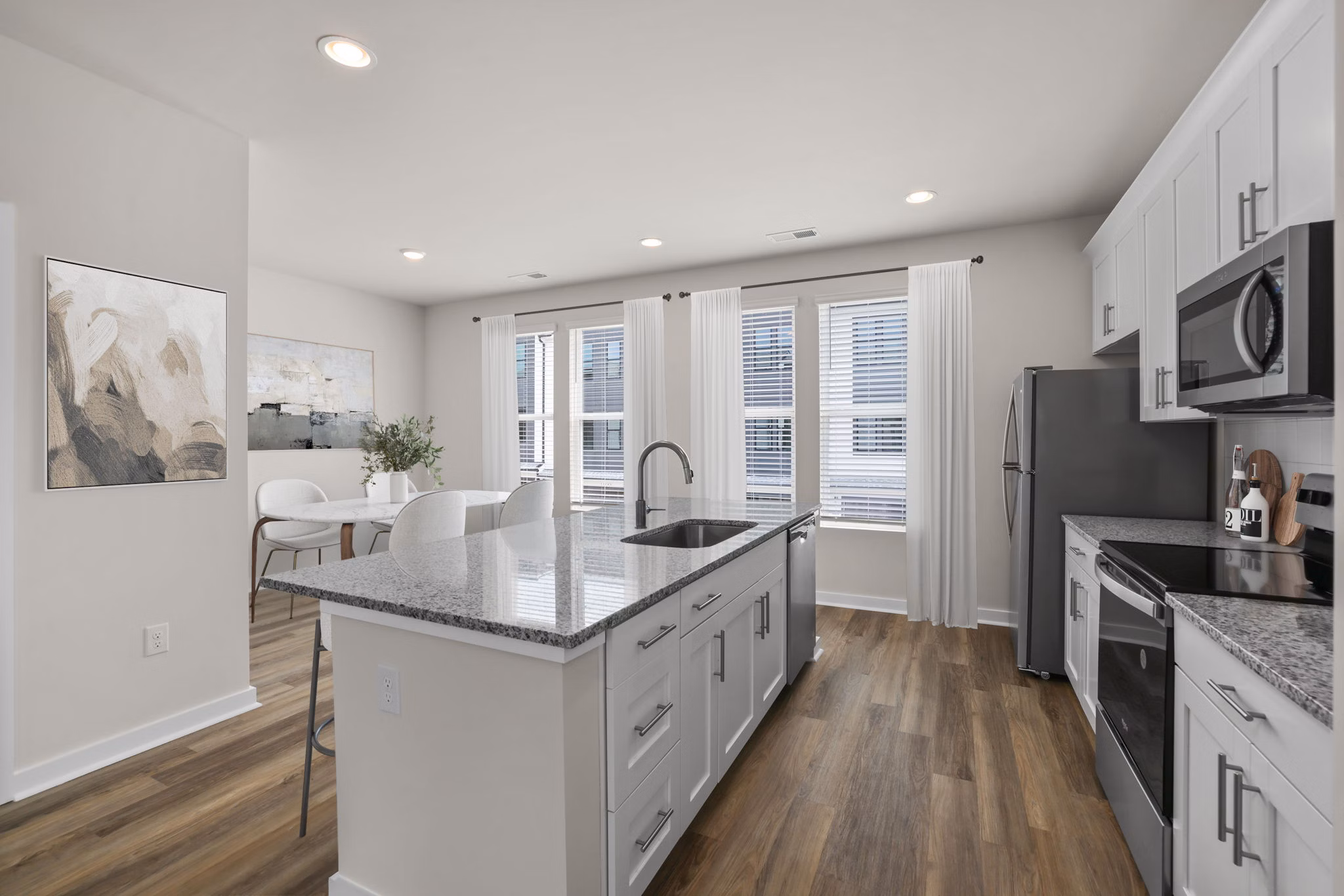 Modern kitchen with stainless steel appliances and granite countertops in Gladwen Wendell Falls Apartments