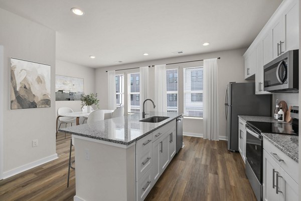 Modern kitchen with stainless steel appliances and granite countertops in Gladwen Wendell Falls Apartments
