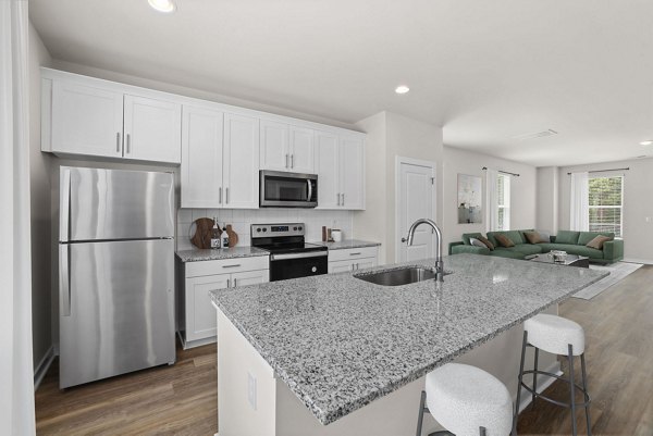 Modern kitchen with stainless steel appliances and spacious countertops at Gladwen Wendell Falls Apartments
