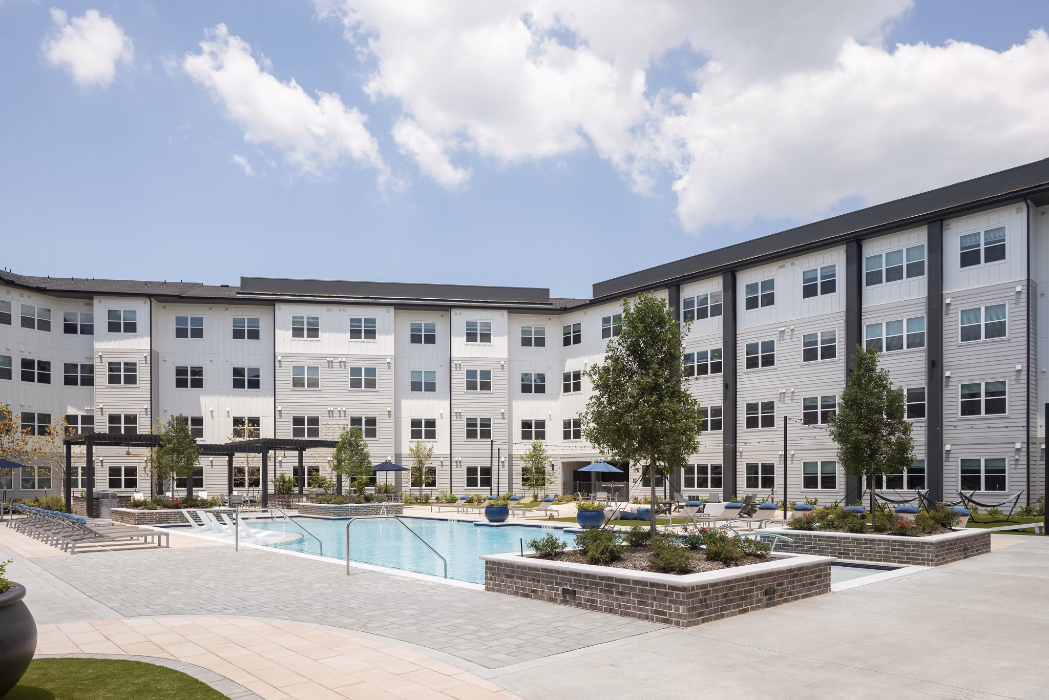 Relaxing pool with lounge chairs at Broadstone Baybrook Apartments offering luxury living in a serene setting