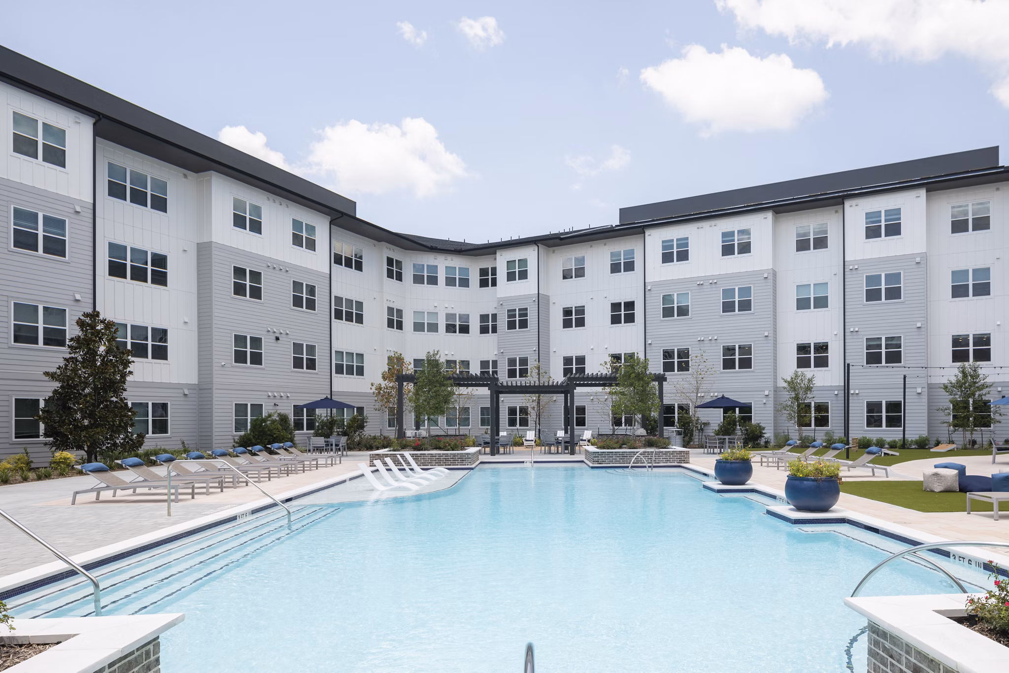 Resort-style pool surrounded by lounge chairs at Broadstone Baybrook Apartments