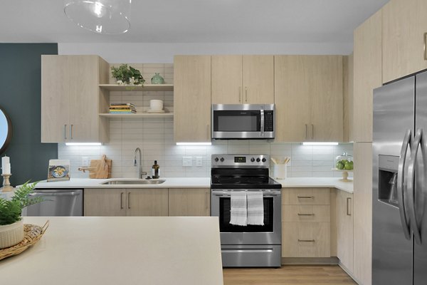 Modern kitchen with stainless steel appliances in Alexan Research Park Apartments