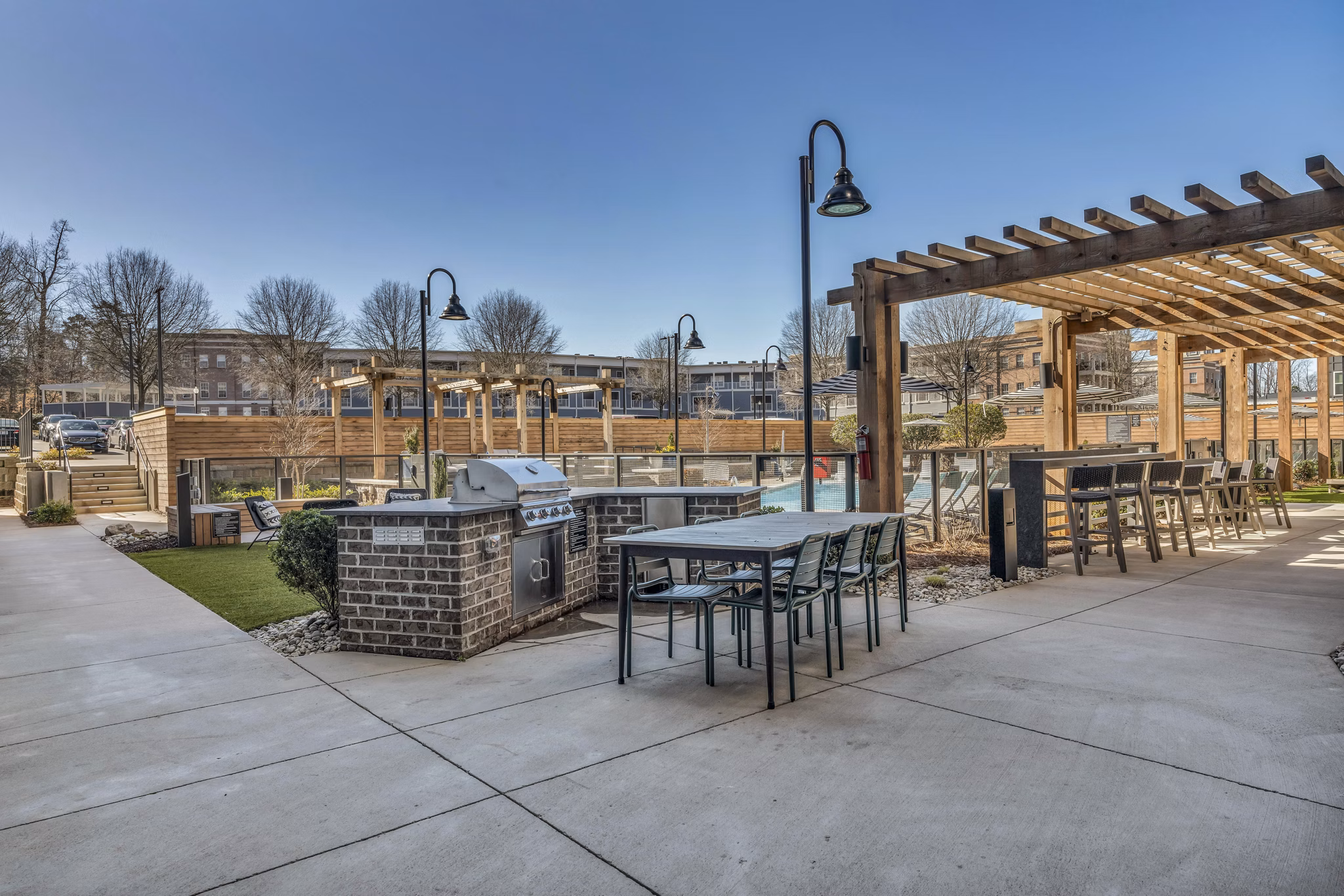 Outdoor grill area featuring modern barbecues at Alexan Research Park Apartments