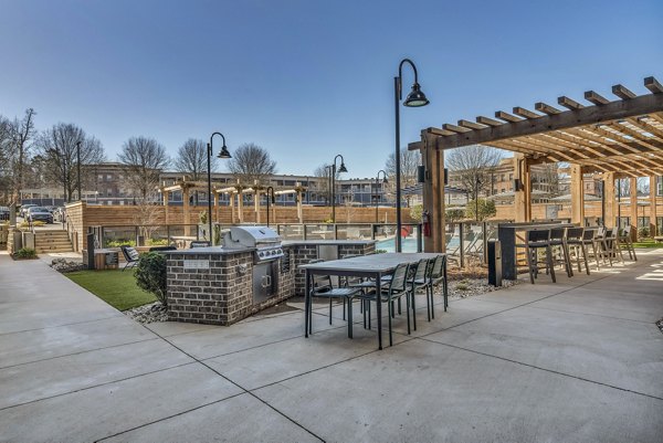 Outdoor grill area featuring modern barbecues at Alexan Research Park Apartments