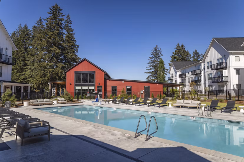 Resort-style pool with sun loungers at The Farmstead Apartments, offering luxury outdoor amenities