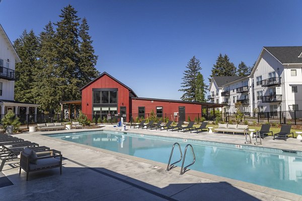 Resort-style pool with sun loungers at The Farmstead Apartments, offering luxury outdoor amenities