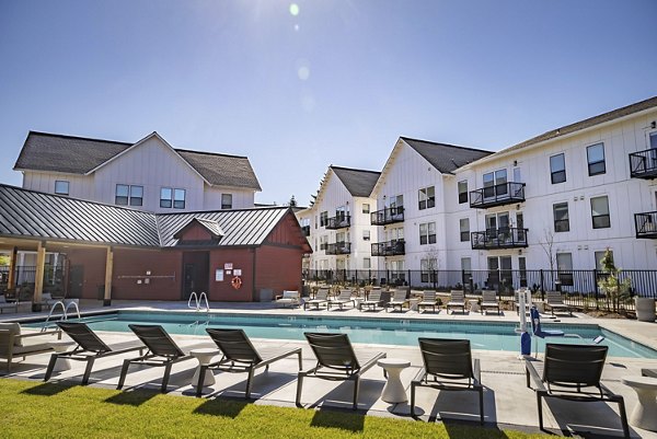 Modern pool with sun loungers at The Farmstead Apartments offering luxury amenities in a serene setting