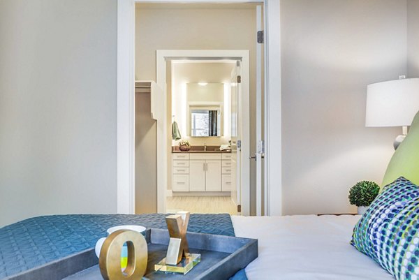 Bedroom with modern furnishings and large window at Incline at Anthem Apartments, offering a luxurious and comfortable living experience