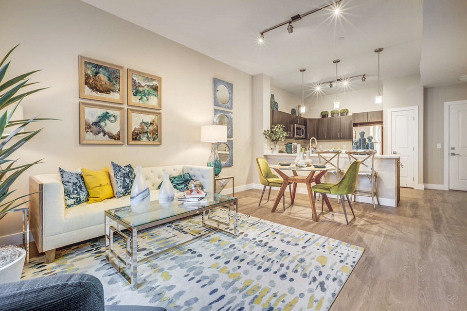Contemporary living room at Incline at Anthem Apartments with plush seating and large windows