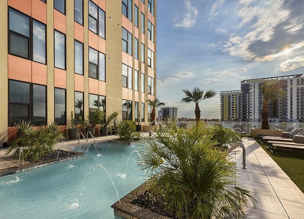 Inviting pool at Derby Apartments featuring lounge chairs and palm trees, perfect for relaxing in a luxurious environment