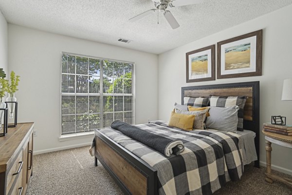 Bedroom featuring elegant decor and large windows at The Vinings at Duncan Chapel Apartments
