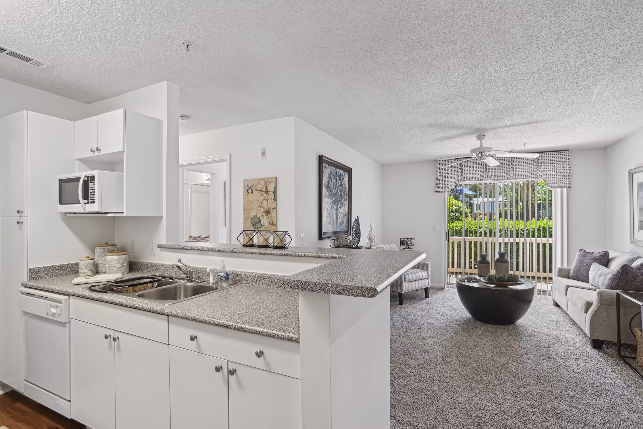 Modern kitchen with sleek granite countertops and stainless steel appliances in The Vinings at Duncan Chapel Apartments