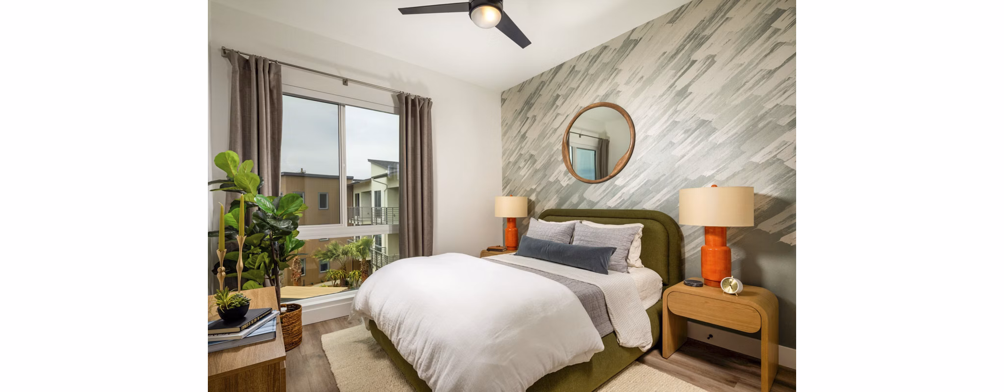 Triton Encinitas Apartments: Cozy bedroom featuring plush bedding and natural light