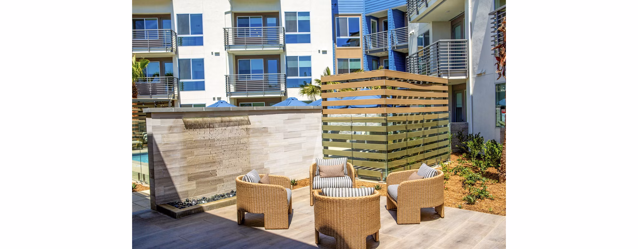 Triton Encinitas Apartments: Cozy patio with modern furniture and lush greenery, ideal for relaxing or entertaining outdoors