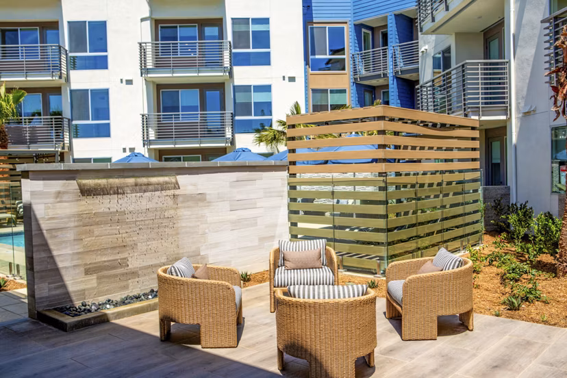 Triton Encinitas Apartments: Cozy patio with modern furniture and lush greenery, ideal for relaxing or entertaining outdoors