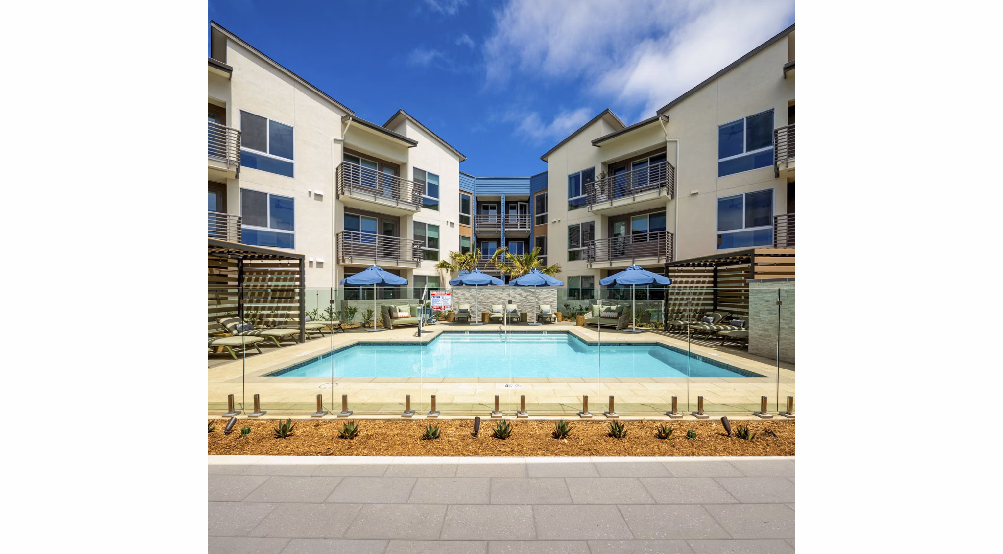 Pool with resort-style seating at Triton Encinitas Apartments offering luxury living