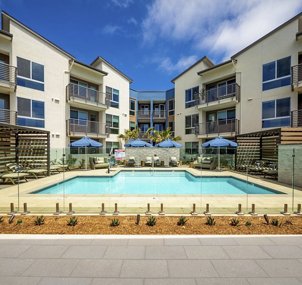 Pool with resort-style seating at Triton Encinitas Apartments offering luxury living